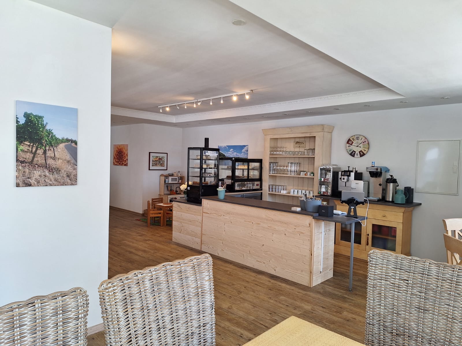 Tresen aus hellem Holz mit Kaffeemaschine und Gläserregal