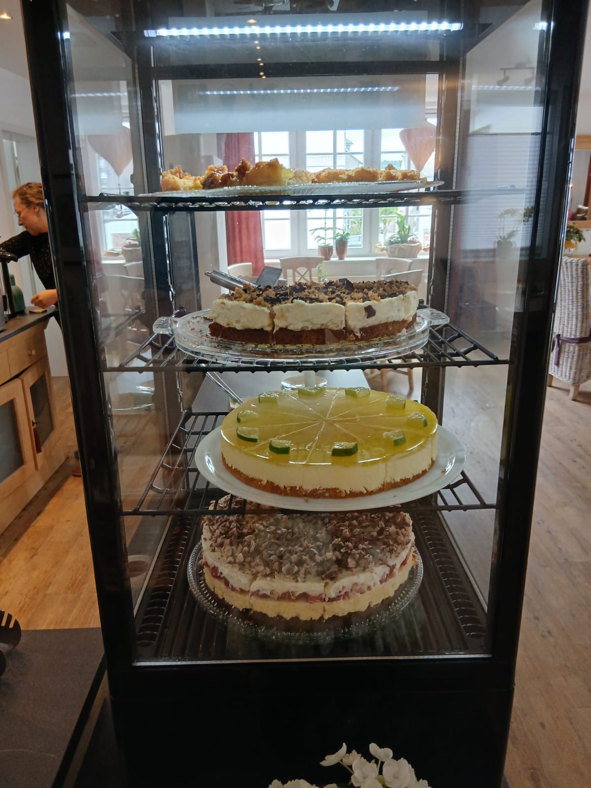 Kuchenvitrine mit Limettentorte und weiteren Kuchen, auch vegan